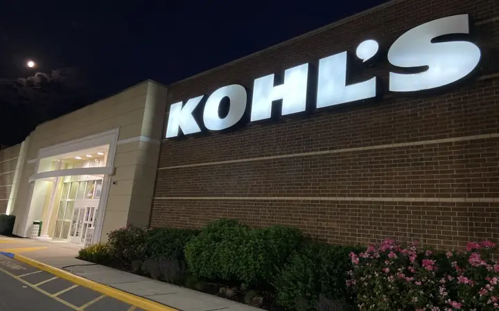 Retail storefront exterior with a lit sign at night, commercial painting in South Jersey